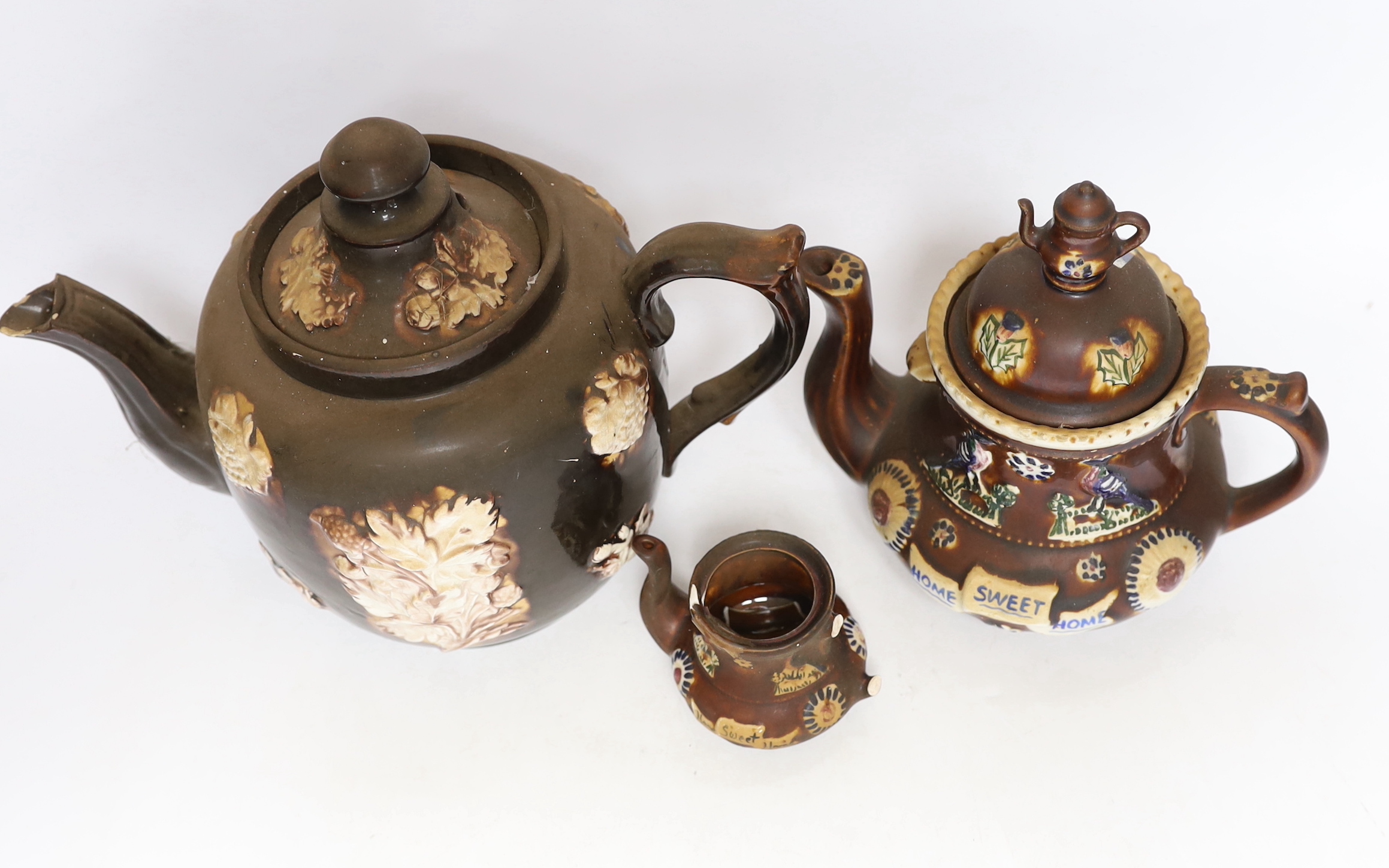 Three 19th century various sized Measham Barge ware teapots, largest 22cm high